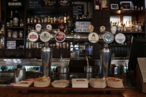 A row of craft beer taps at a cosy pub bar